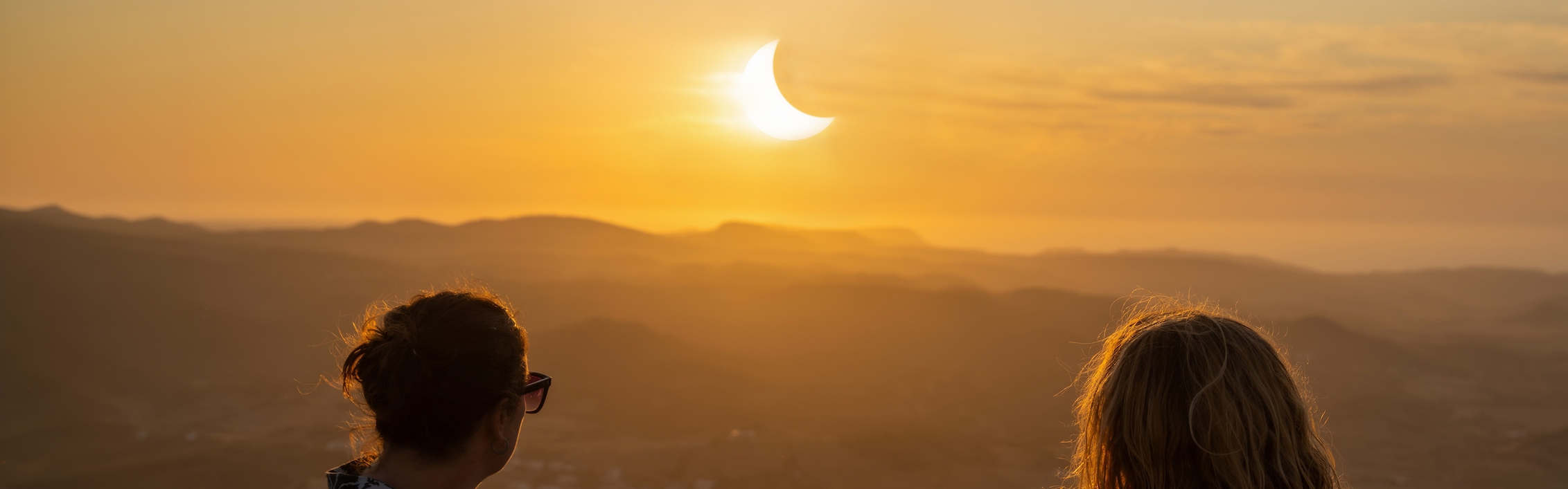 Zwei Frauen beobachten eine Sonnenfinsternis auf den Balearen.