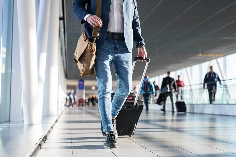 Mann mit Handgepäck am Flughafen