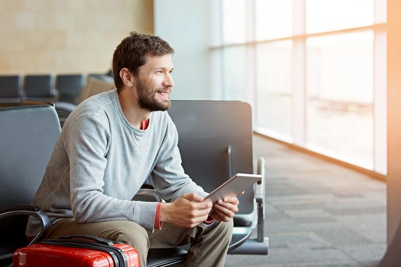 Mann nutzt WLAN mit E Reader am Flughafen