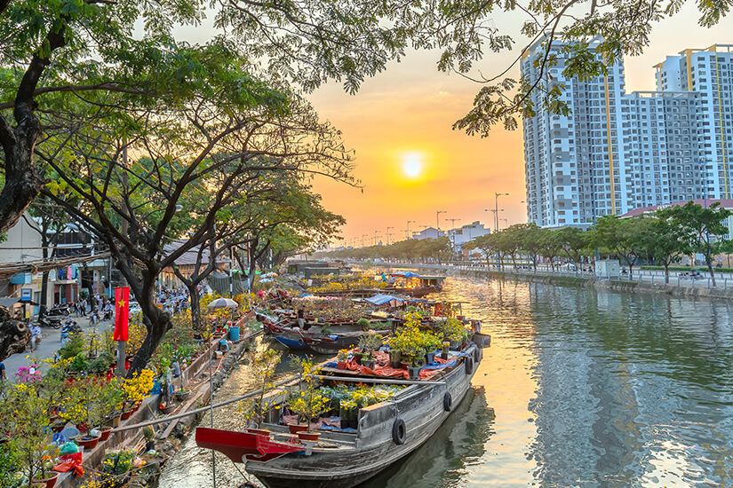 Abendliches Saigon mit Blumenmarkt am Wasser
