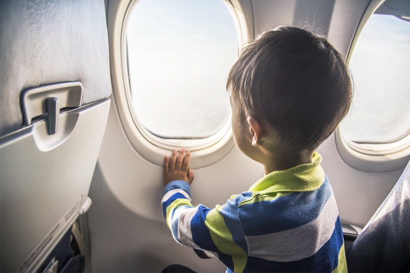 Kind-blickt-aus-dem-Flugzeug