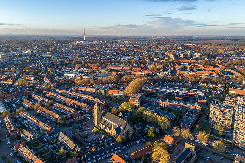 Blick über die Dächer der Stadt bei Sonnenuntergang mit einer Kirche im Mittelpunkt. Hilversum Stadt
