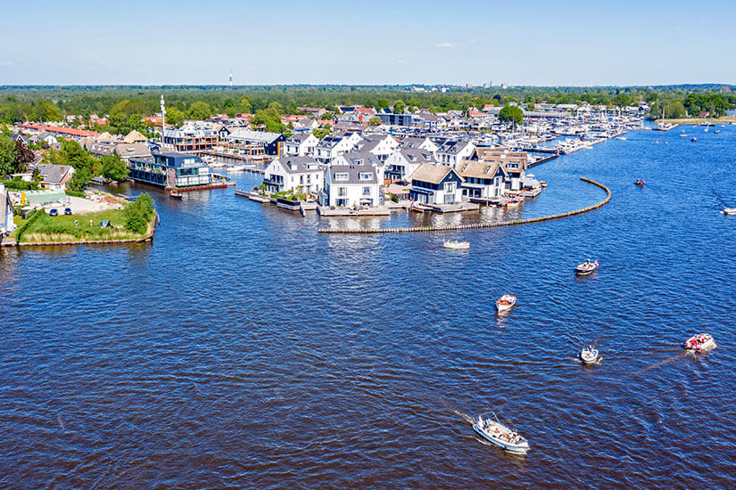 Seenlandschaft mit vielen kleinen Booten und Häusern an der Uferpromenade. Holland Wassersport