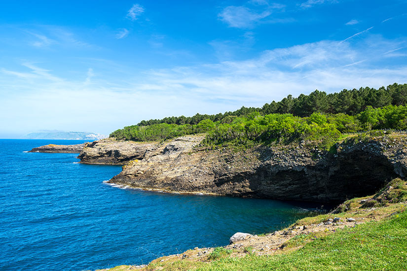 Grün bewaldete Felsen ragen ins Meer hinein. Tuerkei Hamsilos