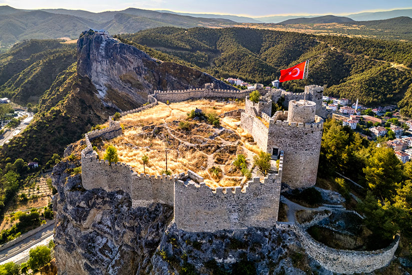 Eine Festung thront auf einem Felsen, eine große türkische Flagge ist zu sehen. Tuerkei Boyabat