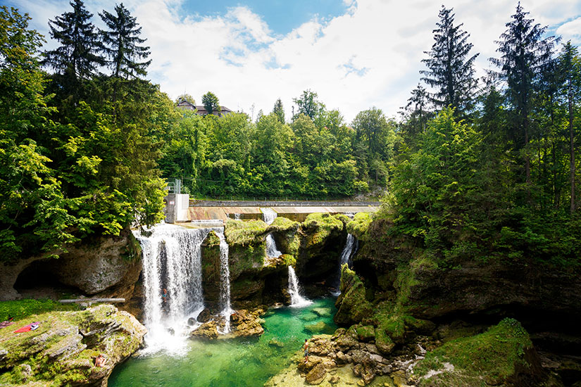 Wasserfall umgeben von grünen Bäumen. Oesterreich Traunfall