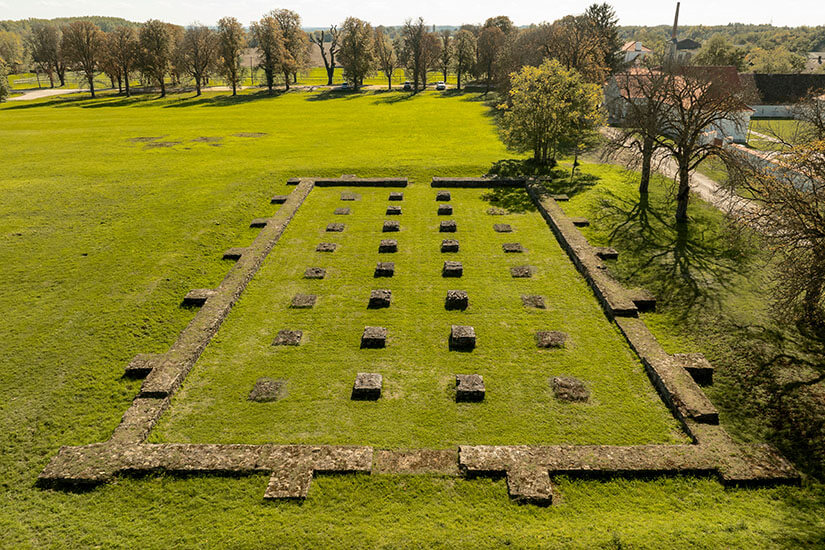 Blick von oben auf die Überreste einer römischen Siedlung, die inmitten grüner Natur liegt. Fenekpuszta Roemische Ruinen