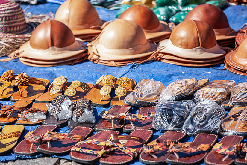 Im Hintergrund sind mehrere traditionelle Lederhüte aufgestapelt, deren runde Form und glatte Oberfläche ins Auge fallen. Souvenirs Brasilien Lederhuete