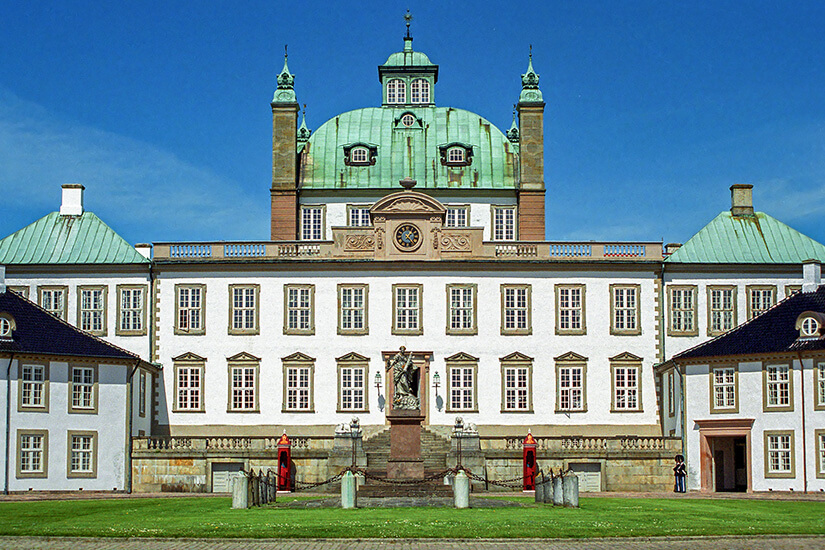 Das "Friedensschloss" nahe Helsingör. Ein majestätisches weißes Gebäude mit seinen grünen Dächern thront im Grünen. Helsingor Daenemark Fredensborg