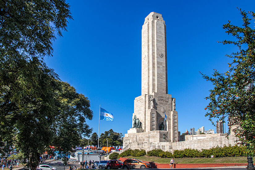 Das Nationaldenkmal der Flagge in Rosario thront auf einer Grünanlage. Der weiße Steinturm ragt in den blauen Himmel. Rosario Argentinien Denkmal