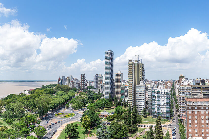 Die Stadt Rosario mit verschiedenen Hochhäusern und Grünanlagen am Fluss ist zu sehen. Rosario Argentinien Wetter
