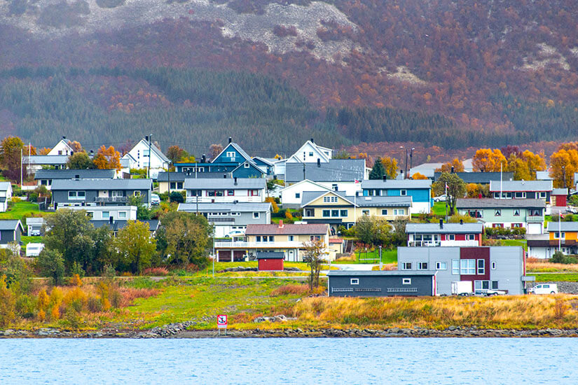 Die Kleinstadt Stokmarknes liegt am Wasser und ist von herbstlichem Forst umgeben. Vesteralen Norwegen Stokmarknes