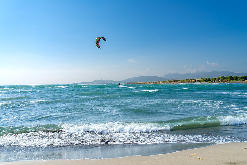 Ada Bojana in Montenegro mit breitem Ufer, flachem Wasser und Kites am Himmel. Strände Montenegro Kitesurfer