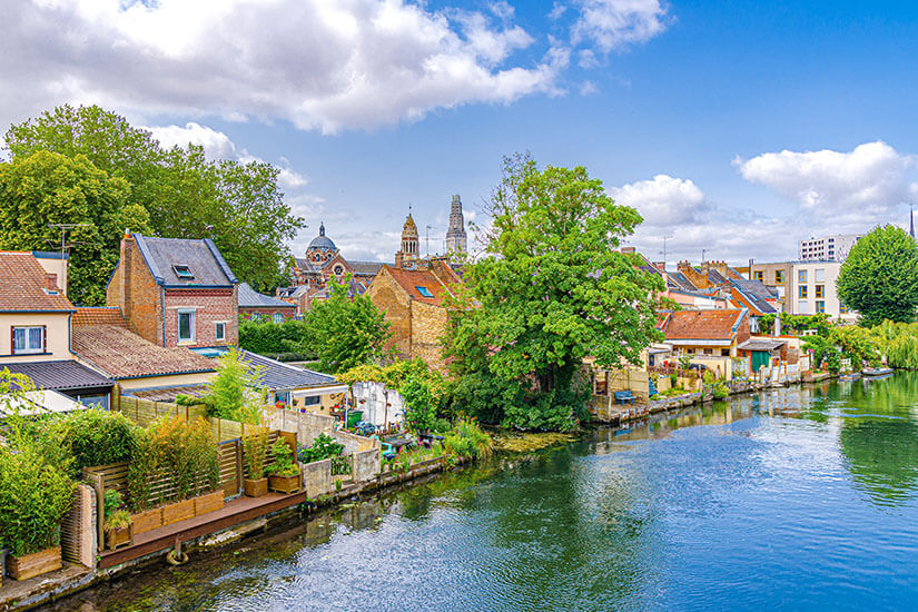 Ein Wasserkanal fließt durch die Stadt Amiens vorbei an kleinen Häusern und viel Grün. Picardie Frankreich Amiens