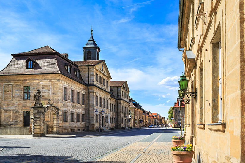 Prächtige Sandsteinfassaden säumen eine der historischen Straßen Bayreuths. Die barocke Architektur zeugt von der Blütezeit unter Markgräfin Wilhelmine im 18. Jahrhundert. Kopfsteinpflaster und schmiedeeiserne Laternen verleihen der Szenerie zeitlosen Charme. Bayreuth Deutschland Altstadt