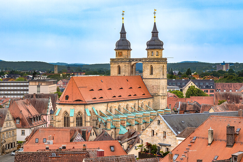 Die imposante Stadtkirche mit ihren markanten Doppeltürmen erhebt sich über die Dächer der Altstadt. Die Sandsteinfassade und die goldenen Turmspitzen sind ein unverkennbares Wahrzeichen. Von hier aus überblickt man das historische Zentrum Bayreuths. Bayreuth Deutschland Stadtkirche