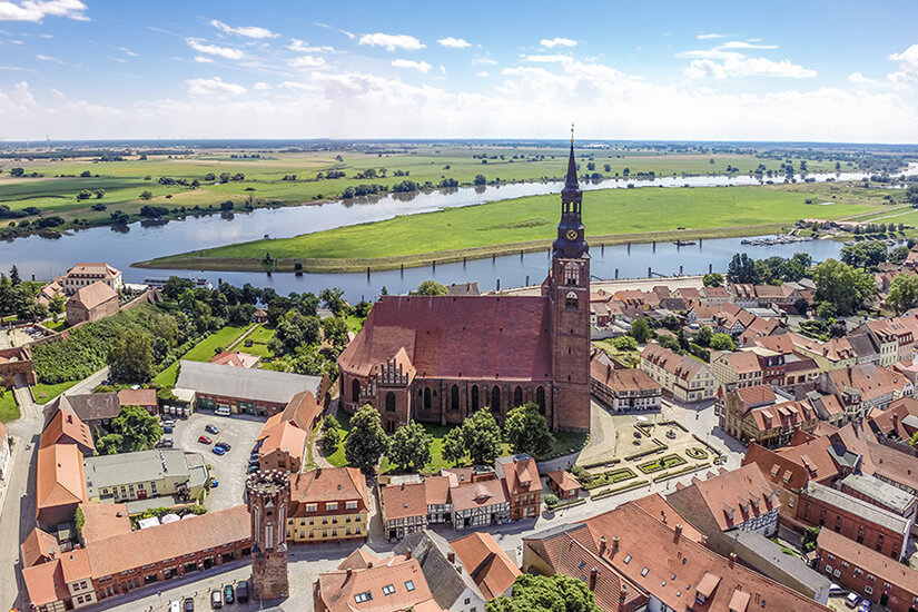 Ein Blick auf die Stadt Tangermünde aus der Vogelperspektive. Rote Dächer, die Stephanskirche und die Elbe sind zu sehen. Tangermuende Deutschland