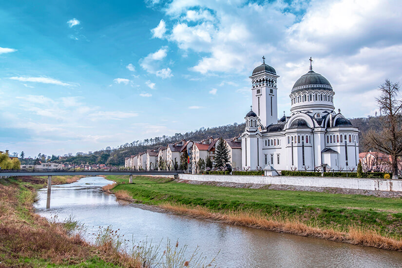 Der Fluss Târnava Mare führt durch Schäßburg, vorbei an einem prächtigen sakralem Bauwerk. Sighisoara Rumaenien Fluss