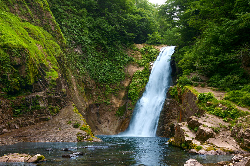Der Akiu Otaki Wasserfall stürzt über moosbedeckte Felsen in ein türkisblaues Becken hinab. Umgeben von üppigem Grün wirkt die Szenerie wie aus einem japanischen Märchen. Der Akiu-Wasserfall gehört zu den beeindruckendsten Naturschauspielen rund um Sendai. Sendai Japan Akiu Otaki Wasserfall