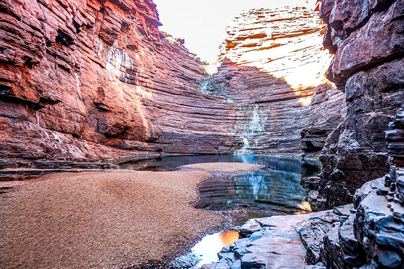 Tief eingeschnittene Schluchten mit leuchtend rot-orange geschichteten Felswänden und einem ruhigen Wasserbecken machen den Karijini Nationalpark zu einem Highlight Westaustraliens. Die jahrtausendealten Gesteinsformationen zählen zu den ältesten der Erde und beeindrucken mit ihrem Farbspiel. Karijini ist einer der schönsten Nationalparks in Westaustralien und ein Muss für Naturliebhaber. Nationalparks Australien Karijini National Park