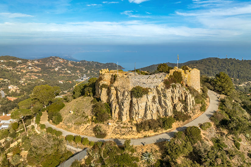 Das Castel de Begur thront auf hellen Felsen und einem grünen Hügel. Begur Spanien Castillo
