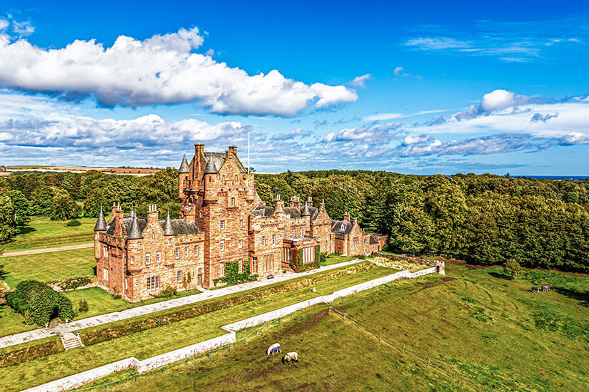 Dieses imposante Herrenhaus aus rotem Sandstein inmitten grüner Wiesen und alter Wälder verkörpert den Charme Schottlands perfekt. Schottland ist eines der beliebtesten Coolcation-Reiseziele Europas – mit milden Sommern, mystischer Landschaft und jahrhundertealter Geschichte. Wer kühle Urlaubsorte im Sommer sucht, wird hier garantiert fündig. Coolcation Europa Schottland