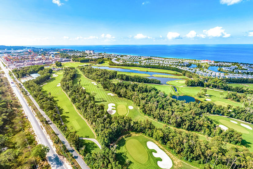 Eine moderne Golfanlage erstreckt sich zwischen üppiger Vegetation und dem tiefblauen Meer am Horizont. Breite Fairways, gepflegte Bunker und mehrere Wasserhindernisse fügen sich harmonisch in die Küstenlandschaft ein. Südostasien entwickelt sich rasant zu einer ernstzunehmenden Adresse für anspruchsvolle Golfer. Golfdestinationen weltweit Vietnam