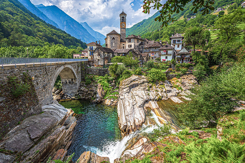 Lavertezzo ist das Herzstück des Verzascatals und besticht mit seiner mittelalterlichen Steinbrücke, dem markanten Kirchturm und den rustikalen Steinhäusern. Das Dorf gehört zu den meistfotografierten Sehenswürdigkeiten im Tessin und ist Ausgangspunkt für Wanderungen entlang der Verzasca. Das smaragdgrüne Wasser unter der Brücke lädt zum Baden ein und macht Lavertezzo zum perfekten Ziel für einen Tagesausflug. Verzascatal Schweiz Lavertezzo