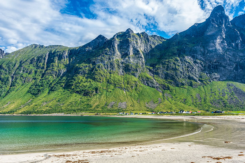 Der Ersfjordstranden ist einer der spektakulärsten Senja Strände – türkisfarbenes Wasser trifft auf weißen Sand, eingerahmt von steil aufragenden Felswänden. Die dramatische Bergkulisse wirkt fast unwirklich und erinnert eher an eine Filmszene als an Nordnorwegen. Dieser Strand gehört ohne Frage zu den absoluten Senja Highlights. Senja Norwegen Ersfjordstranden