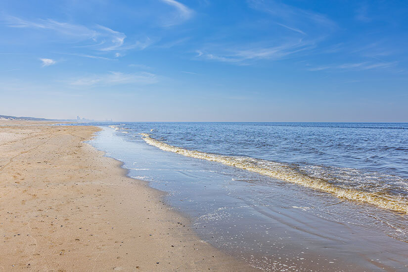 Der Wassenaarseslag südlich von Katwijk aan Zee gilt als einer der ruhigsten und schönsten Strände an der niederländischen Küste und ist ein echter Geheimtipp. Weite Sandflächen und das sanft heranrollende Meer laden zu entspannten Spaziergängen in einer fast menschenleeren Kulisse ein. Wer Ruhe und unverbaute Natur in Holland sucht, findet hier den perfekten Rückzugsort abseits der belebteren Strandabschnitte. Katwijk aan Zee Niederlande Wassenaarseslag