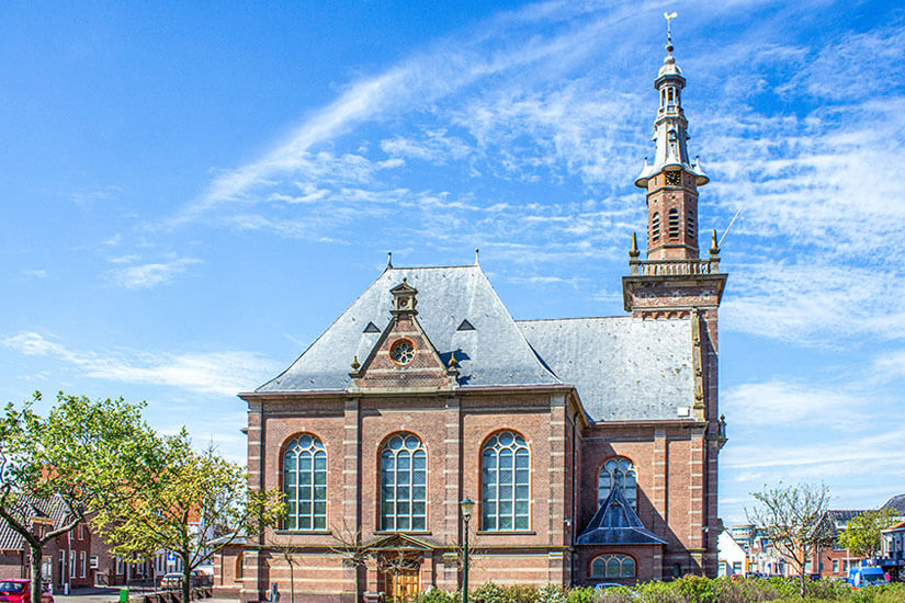 Die historische Kirche im Zentrum von Katwijk aan Zee zählt zu den markantesten Sehenswürdigkeiten der Stadt und prägt das Ortsbild mit ihrem imposanten Turm. Das Backsteingebäude mit seinen hohen Rundbogenfenstern strahlt die typische Architektur niederländischer Küstenorte aus. Rund um die Kirche findet sich ein gemütlicher Platz, der zum Verweilen einlädt und einen authentischen Eindruck vom Leben in Katwijk vermittelt. Katwijk aan Zee Niederlande Kirche