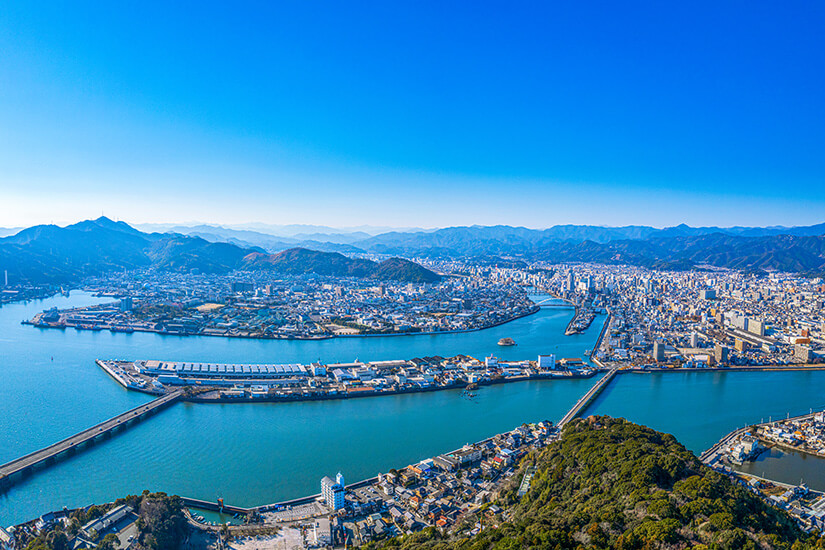 Die Stadt Kochi erstreckt sich weitläufig zwischen Bergen und Meer auf der Insel Shikoku. Vom Berg Godaisan aus eröffnet sich ein atemberaubender Panoramablick über die Hafenstadt mit ihren charakteristischen Flussläufen. Die Hauptstadt der gleichnamigen Präfektur ist das pulsierende Zentrum der Region und ein idealer Ausgangspunkt für Entdeckungstouren. Kochi Japan Stadt