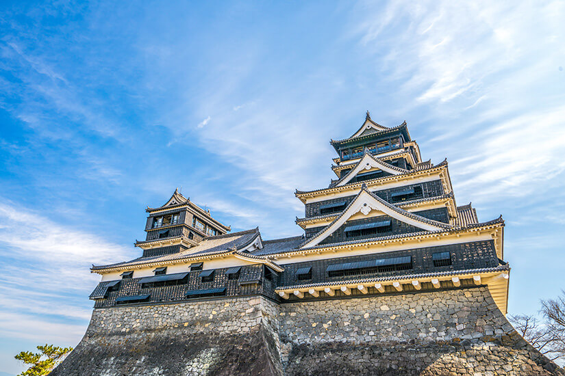 Die imposante Burg Kumamoto erhebt sich mit ihren charakteristischen schwarzen Holzfassaden und den geschwungenen Pagodendächern majestätisch über mächtigen Steinmauern. Als eine der drei berühmtesten Burgen Japans ist sie das unangefochtene Wahrzeichen der Stadt und ein Meisterwerk der Samurai-Architektur. Ihre eleganten Linien heben sich kontrastreich vom blauen Himmel ab und versetzen Besucher in das feudale Zeitalter zurück. Kumamoto Japan Burg