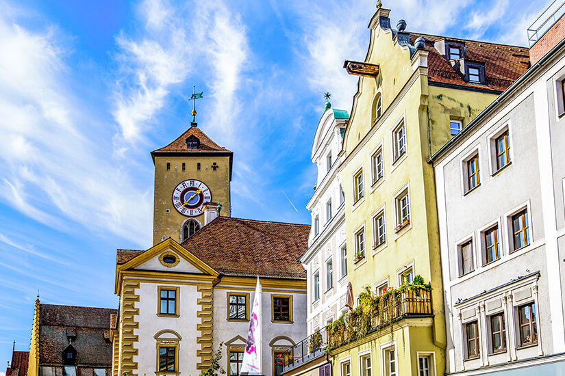 Ein Kirchturm ragt über historischen Gebäuden in Regensburg auf. Altstadt Deutschland Regensburg