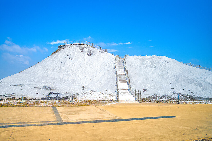 Der schneeweiße Salzberg von Cigu ist das Wahrzeichen der einst größten Salzproduktion Taiwans. Über eine schmale Treppe können Besucher den verdichteten Salzhügel erklimmen und die einzigartige Landschaft von oben bewundern. Heute ist der Ort ein beliebtes Fotomotiv und erinnert an die jahrhundertealte Tradition der Salzgewinnung in dieser Region. Tainan Taiwan Cigu