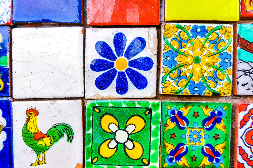 Eine Auswahl bunt bemalter Fließen. Manche zeigen Blumenmuster. Puerto Escondido Mexiko Stadt