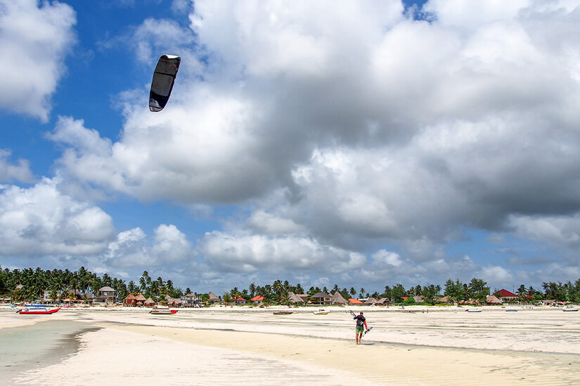 Paje an der Südostküste Sansibars ist das unangefochtene Zentrum der Kitesurfer-Szene auf der Insel. Bei Ebbe entstehen weite, glatte Sandflächen, die ideale Bedingungen für den Wassersport bieten. Über dem hellen Strand ziehen oft dramatische Wolkenformationen am sonst azurblauen Himmel auf. Sansibar Straende Paje Beach