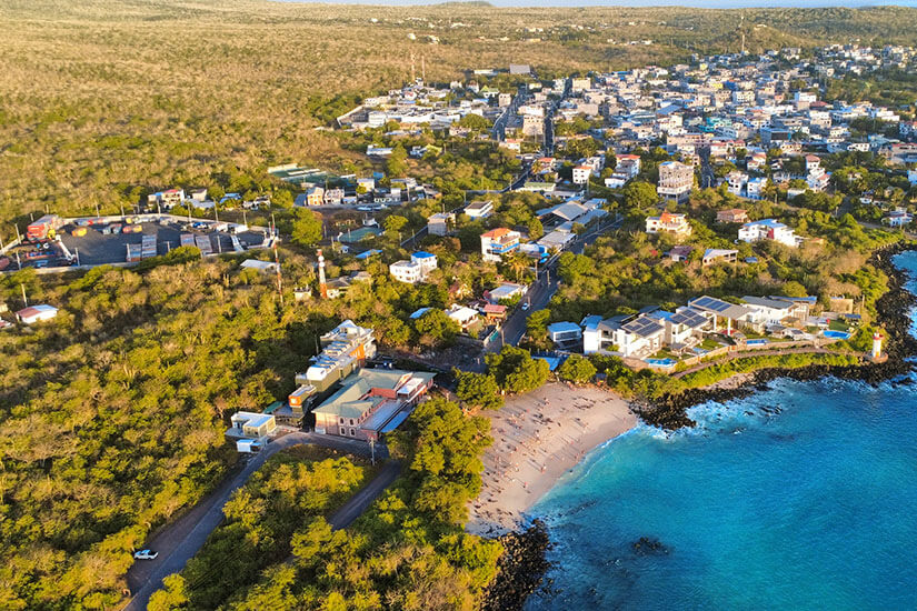 Die Ortschaft Puerto Baquerizo Moreno aus der Vogelperspektive. Blaues Meer liegt an der Küste und viel Grün im Hinterland. Galapagos Ecuador Baquerizo