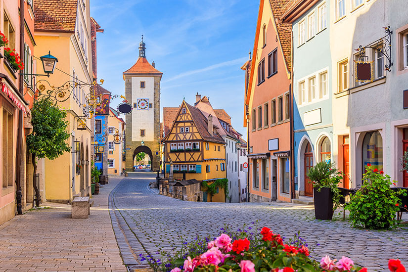 Das berühmte Plönlein in Rothenburg ob der Tauber zeigt eine malerische Gabelung zweier gepflasterter Gassen mit einem markanten, gelben Fachwerkhaus in der Mitte. Schoenste Orte Sueddeutschland Rothenburg