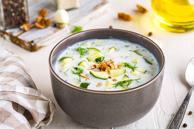 Eine Schüssel gefüllt mit einer Joghurtsuppe und Gurken steht auf einem Tisch. Goldstrand Sonnenstrand Bulgarien Tarator