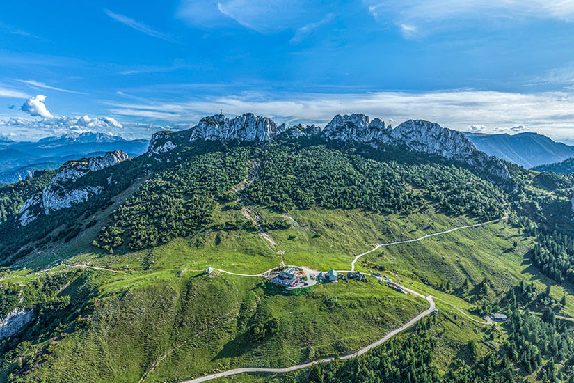 Luftaufnahme der Kampenwand mit ihrer markanten Felssilhouette und der Bergstation der Kampenwandseilbahn. Der Berg gehört zu den beliebtesten Wanderzielen in den Chiemgauer Alpen. Von hier aus eröffnet sich ein weiter Blick über das gesamte Voralpenland. Chiemsee Deutschland Kampenwand