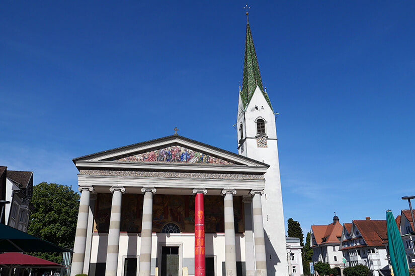 tadtpfarrkirche St. Martin am Marktplatz von Dornbirn. Der grüne Kirchturm und die klassizistische Fassade sind typisch für das Stadtbild. Die Kirche gehört zu den zentralen Sehenswürdigkeiten der Altstadt. Dornbirn Österreich Kirche
