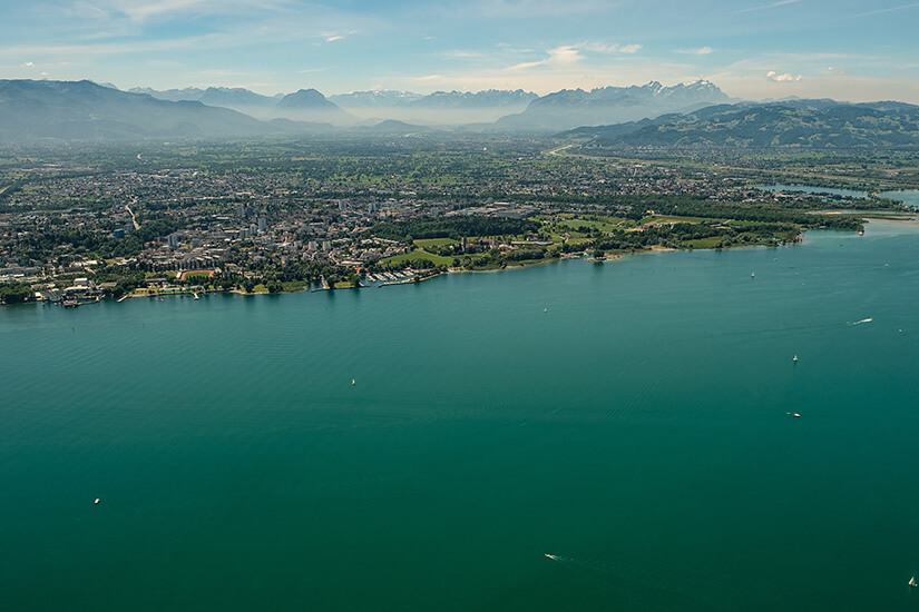 Luftaufnahme des Bodensees bei Bregenz. Hinter der Uferregion sind die Alpen zu sehen. Der See liegt nur wenige Kilometer von Dornbirn entfernt. Dornbirn Österreich Bodensee