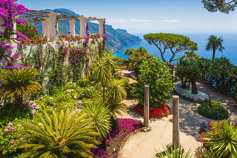 Die üppigen Gärten der Villa Rufolo in Ravello bieten einen der spektakulärsten Ausblicke der gesamten Amalfiküste. Exotische Pflanzen, leuchtende Blumenbeete und antike Säulen bilden ein malerisches Ensemble hoch über dem Meer. Amalfiküste Italien Ravello