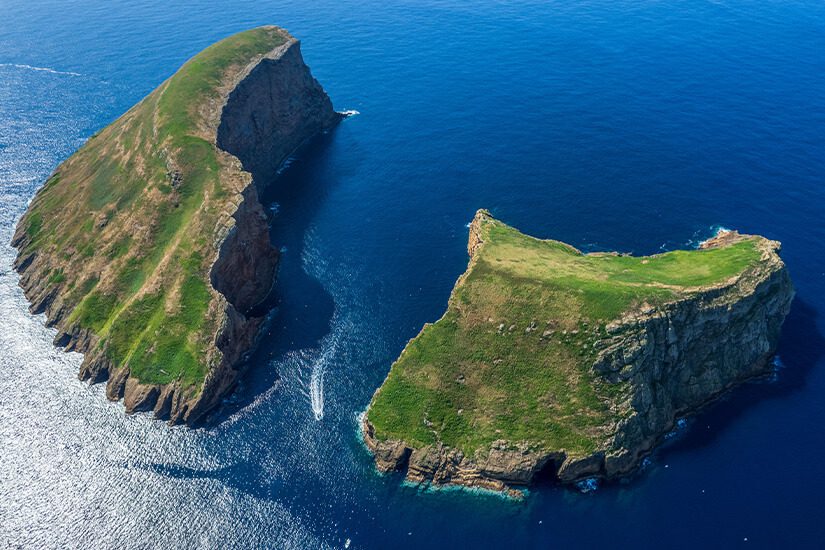 Zwei schroffe, grün bewachsene Felseninseln ragen aus dem tiefblauen Atlantik empor. Steile Klippen und tosende Gischt unterstreichen die Wildheit dieser Landschaft. Unberührte Natur, wie man sie nur selten in Europa findet. Azoren Portugal Terceira