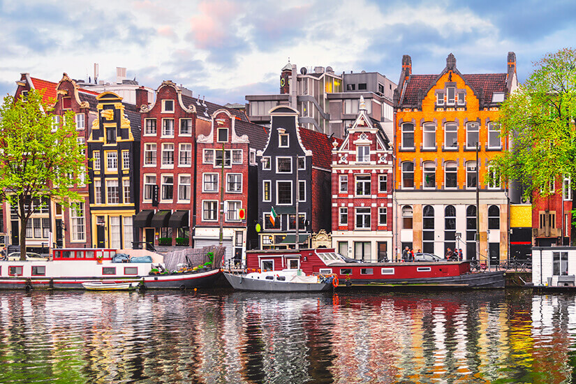 Bunte, schmale Grachtenhäuser mit Treppen- und Glockengiebeln reihen sich leicht schief aneinander. Reiseziele September Amsterdam