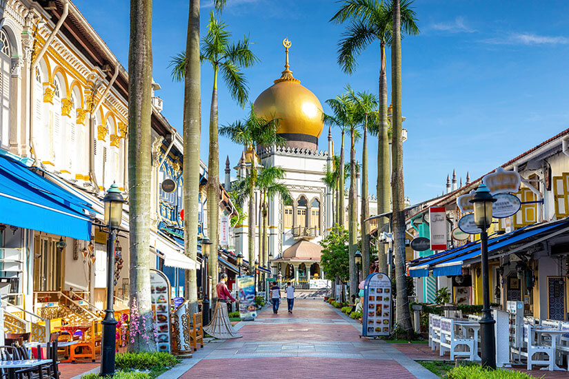 Am Ende einer palmengesäumten Fußgängerstraße im Singapurer Viertel Kampong Glam glänzt die goldene Kuppel der Sultan-Moschee vor blauem Himmel. Wo ist es im Winter warm Singapur