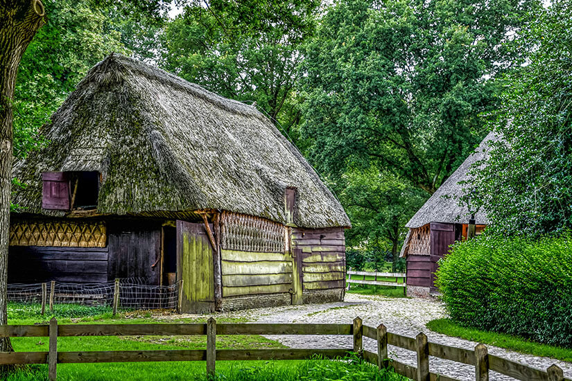 Reetgedeckte sächsische Bauernhöfe im Museumsdorf Orvelte, verbunden durch kopfsteingepflasterte Wege und umgeben von üppigem Grün. Der denkmalgeschützte Ort liegt rund 30 Autominuten nordwestlich von Emmen. Emmen Niederlande Orvelte