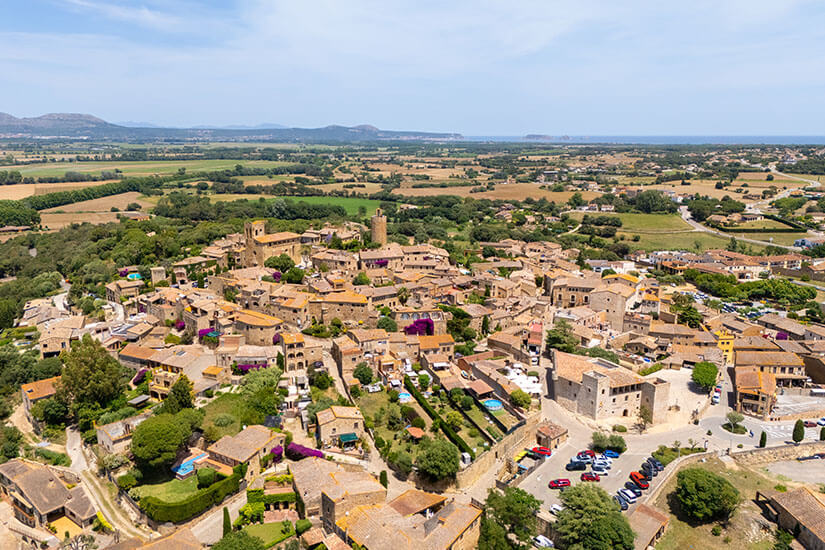 Die Stadt Pals aus der Vogelperspektive betrachtet. Heller Sandstein leuchtet zwischen grüner Landschaft. Pals Spanien Willkommen