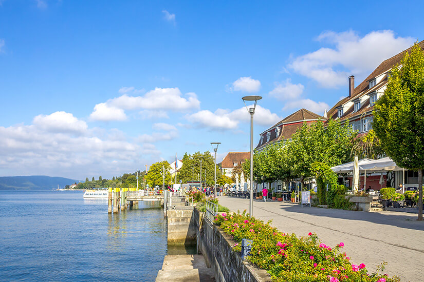Überlingens Seepromenade ist zu sehen, mit viel Grün und Blumenbeeten. Ueberlingen Deutschland Uferpromenade